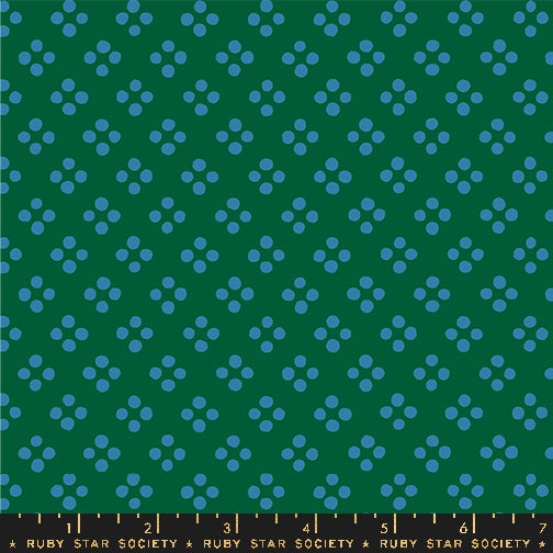 A repeating fabric pattern featuring small blue flower-like clusters on a dark green background, with a black ruler strip at the bottom labeled Ruby Star Society.
