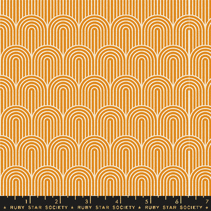 A repeating fabric pattern featuring orange and white concentric arches in a retro mid-century modern design, with a black ruler at the bottom showing the scale of the pattern.