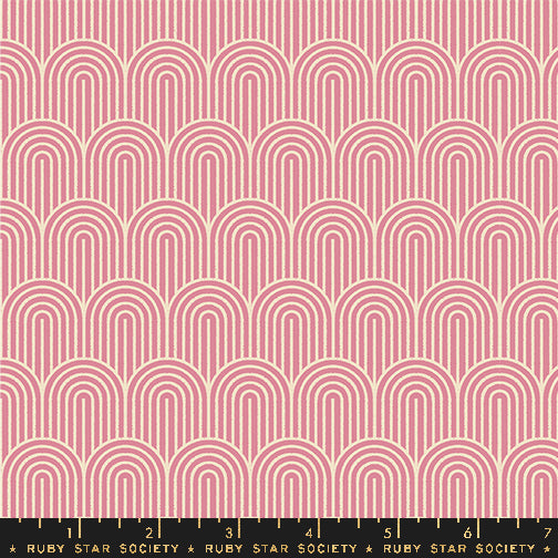 A repeating fabric pattern featuring pink and cream arches in a retro, geometric design, with a black measuring ruler at the bottom showing the scale of the pattern.
