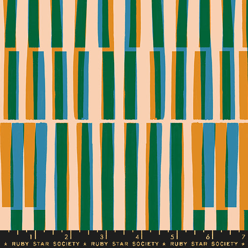 Fabric with a repeating vertical stripe pattern with alternating tall green, blue, and orange stripes on a warm beige background, with a black ruler strip labeled Ruby Star Society at the bottom for scale.