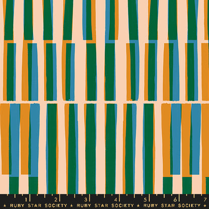 Fabric with a repeating vertical stripe pattern with alternating tall green, blue, and orange stripes on a warm beige background, with a black ruler strip labeled Ruby Star Society at the bottom for scale.