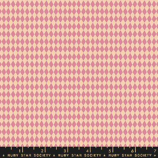 A close-up of a repeating harlequin diamond pattern in dusty pink and pale peach, with a black ruler strip along the bottom edge labeled Ruby Star Society.