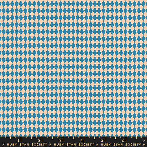 A repeating harlequin diamond pattern in blue and warm cream, shown flat with a black Ruby Star Society ruler along the bottom edge.