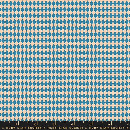 A repeating harlequin diamond pattern in blue and warm cream, shown flat with a black Ruby Star Society ruler along the bottom edge.