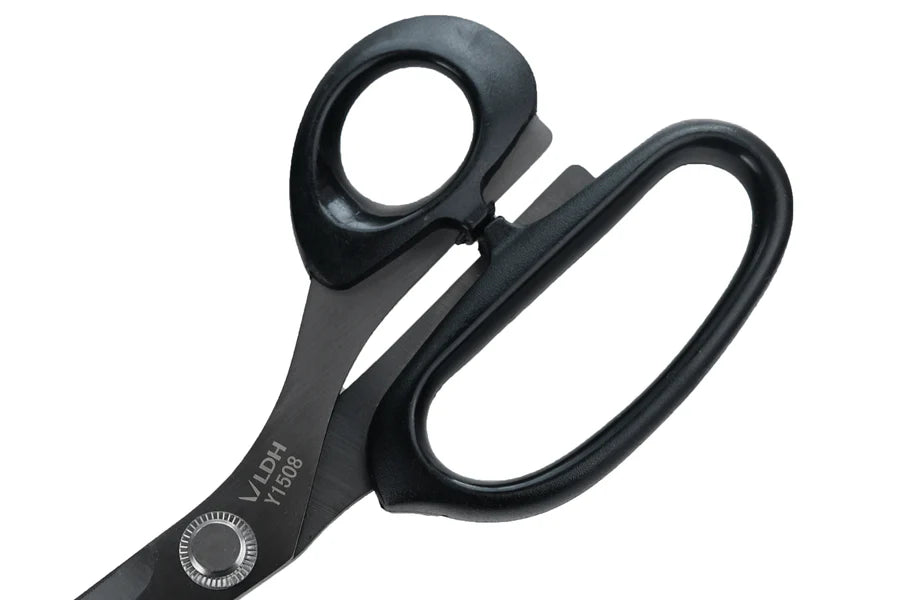 Close up of handles of black scissors with visible branding on a white background