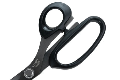 Close up of handles of black scissors with visible branding on a white background