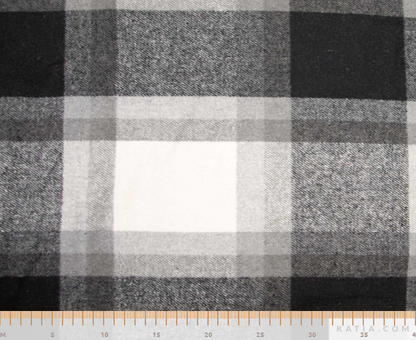 Black, gray, and white plaid fabric with a visible ruler along the bottom edge for scale.