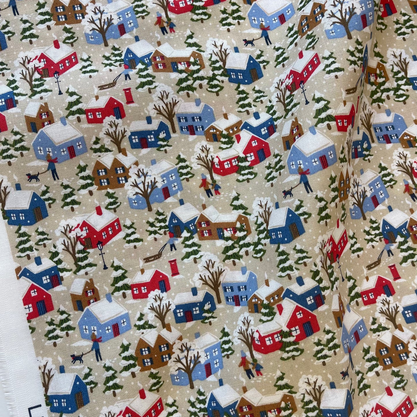 Fabric with winter snowy houses design from Liberty of London for sewing quilting and crafting. 