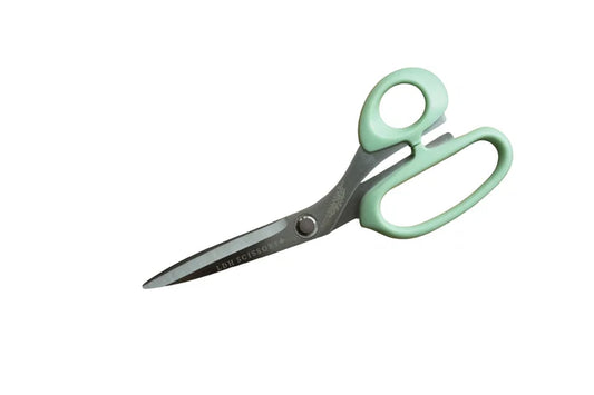 Pair of scissors with green handles on a white background for sewing and crafting.