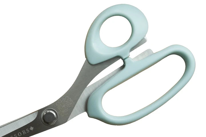 Scissors with light blue handles on a white background for sewing and crafting.
