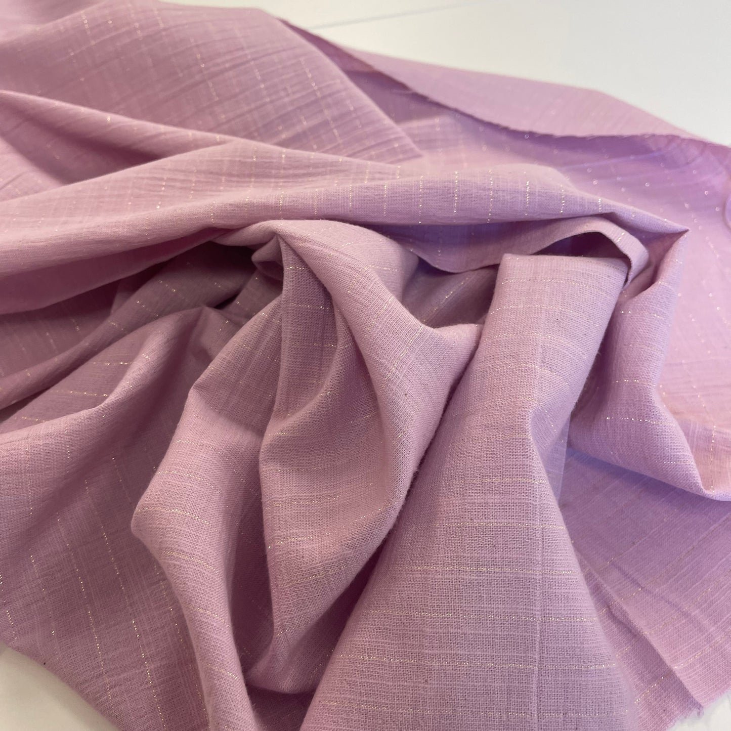 Close-up of purple fabric with a gold stripes textured pattern