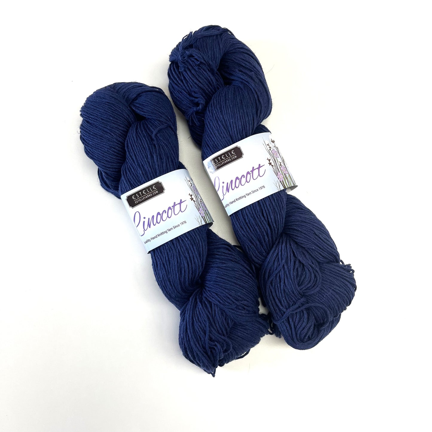 Two skeins of dark navy blue yarn with white paper bands labeled 'Raspberry Creek Fabrics' and 'Pinocott', displayed on a clean white background.