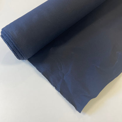 A close-up of a navy waxed canvas fabric material for sewing and crafting and bag making.