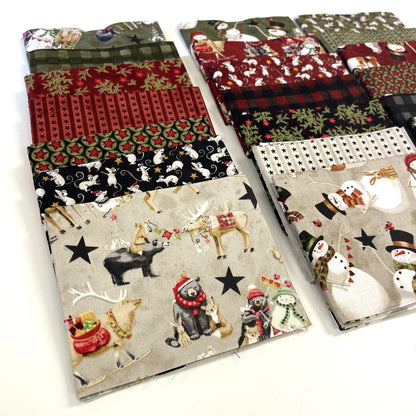 Collection of Christmas-themed fabric swatches with reindeer, snowmen, and other winter elements for sewing and quilting