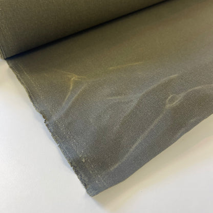 A close-up of a olive green waxed canvas fabric material for sewing and crafting and bag making.