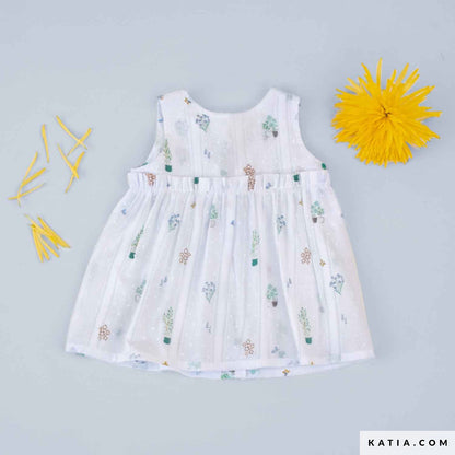 White baby dress in cotton fabric with small plant and flower illustrations. 