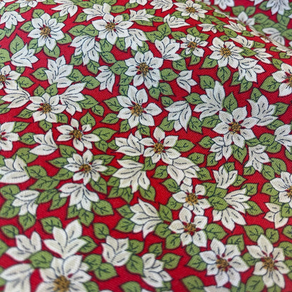 Fabric with white poinsettias on a red background from Liberty Fabrics for Christmas sewing, quilting, and crafting. 