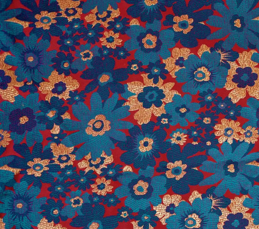Colorful floral pattern brocade material with blue, red, and gold flowers on a fabric background.