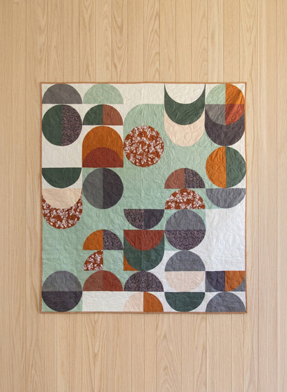 Geometric patterned fabric quilt on a wooden floor from Soar by Katerina Roccella Art Gallery Fabrics premium cotton for sewing and crafting.