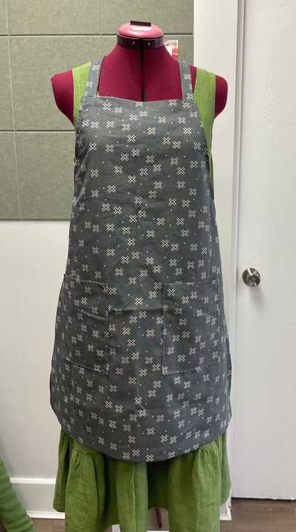 a tie back apron in cotton linen blend displayed on a sewing dummy for sewing lesson and workshop.