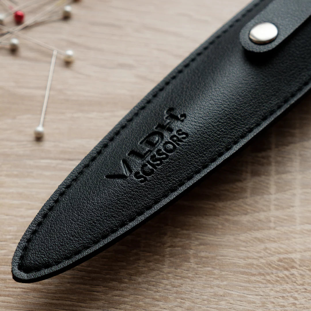 Tip of a black leather scissor or shear sheath.