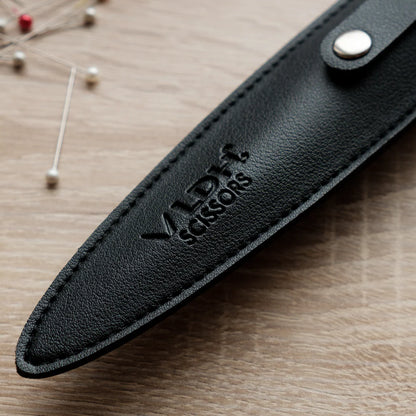 Tip of a black leather scissor or shear sheath.