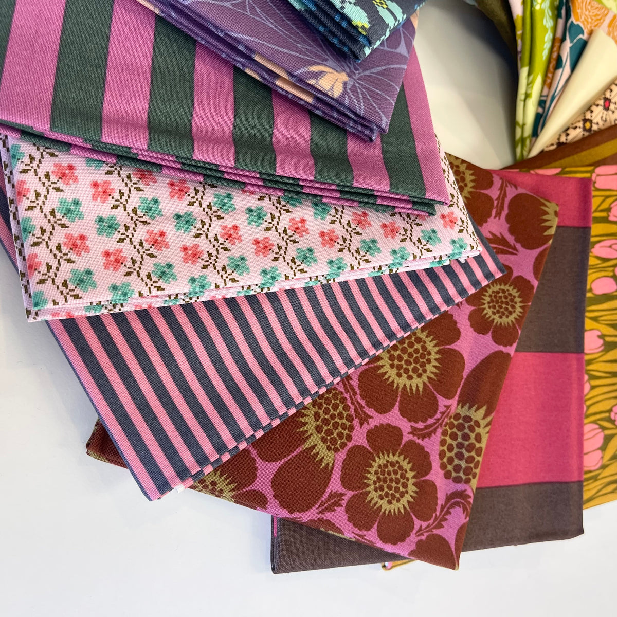 A stack of vintage inspired fat quarter fabrics for sewing and quilting, from Anna Maria Textiles. 
