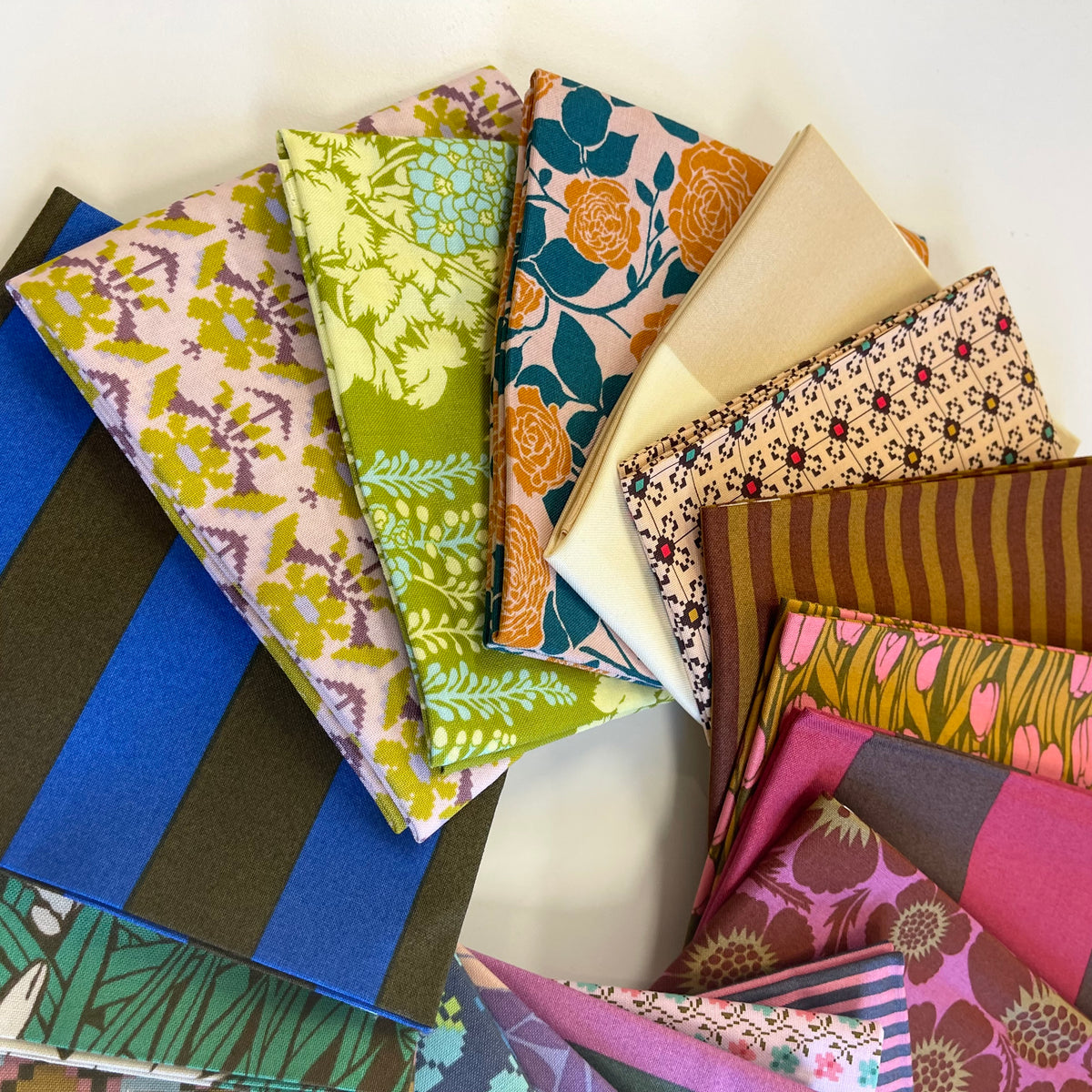 A stack of vintage inspired fat quarter fabrics for sewing and quilting, from Anna Maria Textiles. 