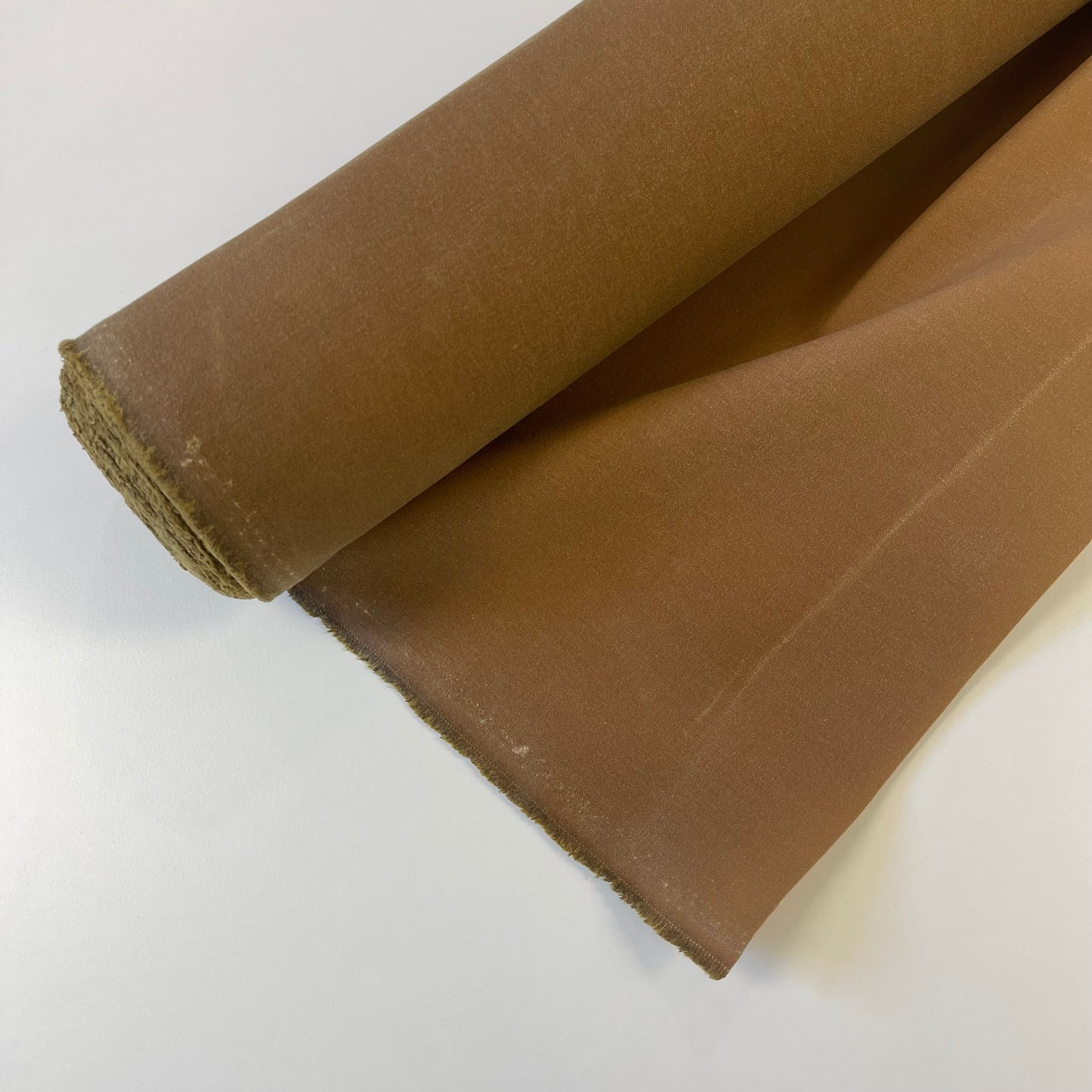 A close-up of a khaki brown waxed canvas fabric material for sewing and crafting and bag making.