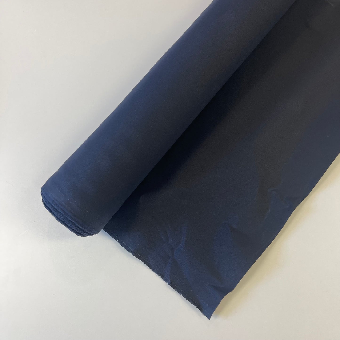A close-up of a navy waxed canvas fabric material for sewing and crafting and bag making.