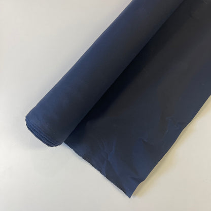 A close-up of a navy waxed canvas fabric material for sewing and crafting and bag making.