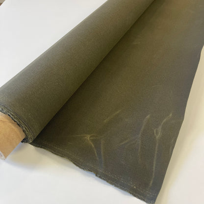 A close-up of a olive green waxed canvas fabric material for sewing and crafting and bag making.
