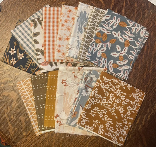 Collection of fabric swatches with various patterns on a wooden surface. fat quarter bundle from FIGO fabrics bundle of 14. 