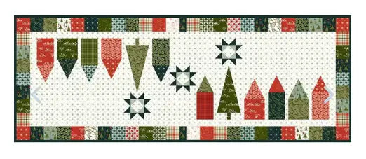 A table runner kit with a Christmas-themed pattern, including shapes like snowflakes and Christmas trees in a festive, plaid-like fabric.