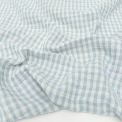 Blue and white checkered organic cotton double gauze fabric on a white background